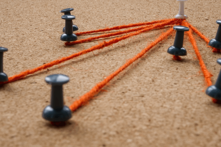Pushpins and connecting strings symbolizing task delegation and team accountability